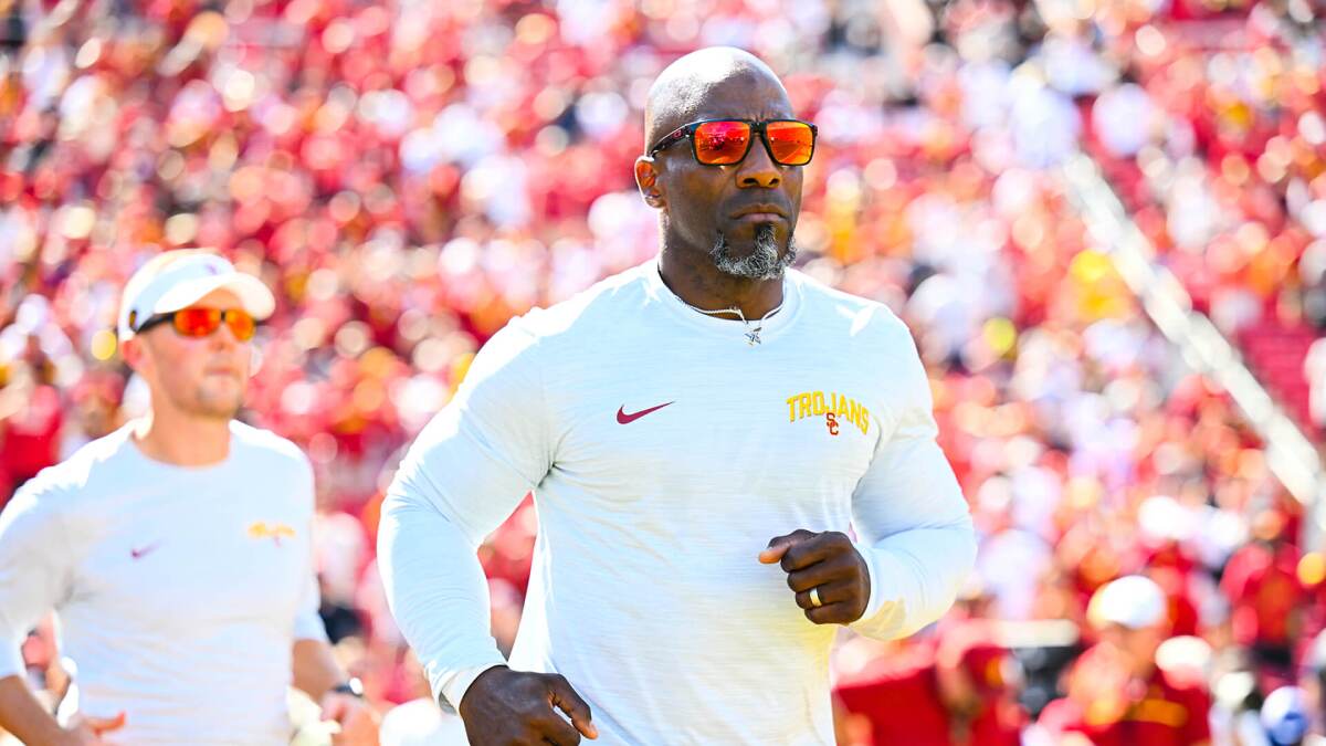 USC strength and conditioning coach Bennie Wylie runs on to the football field.