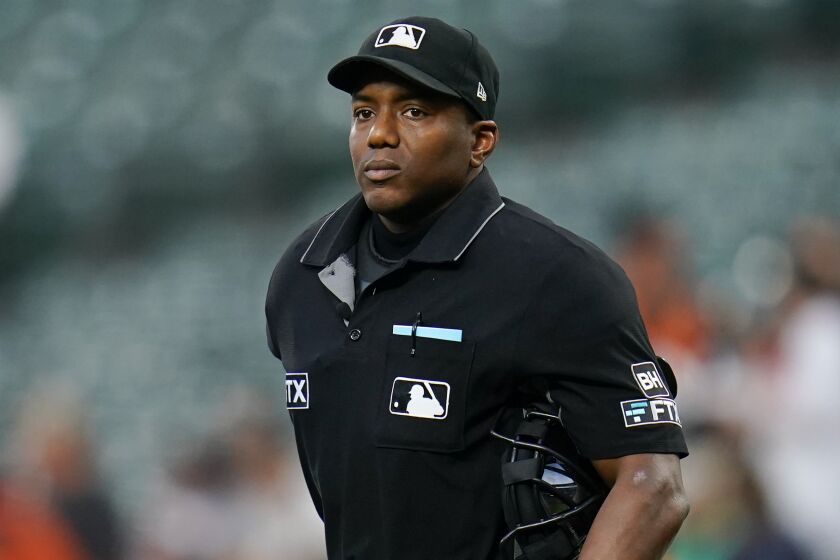 Home plate umpire Malachi Moore looks on during the first inning of a baseball game.