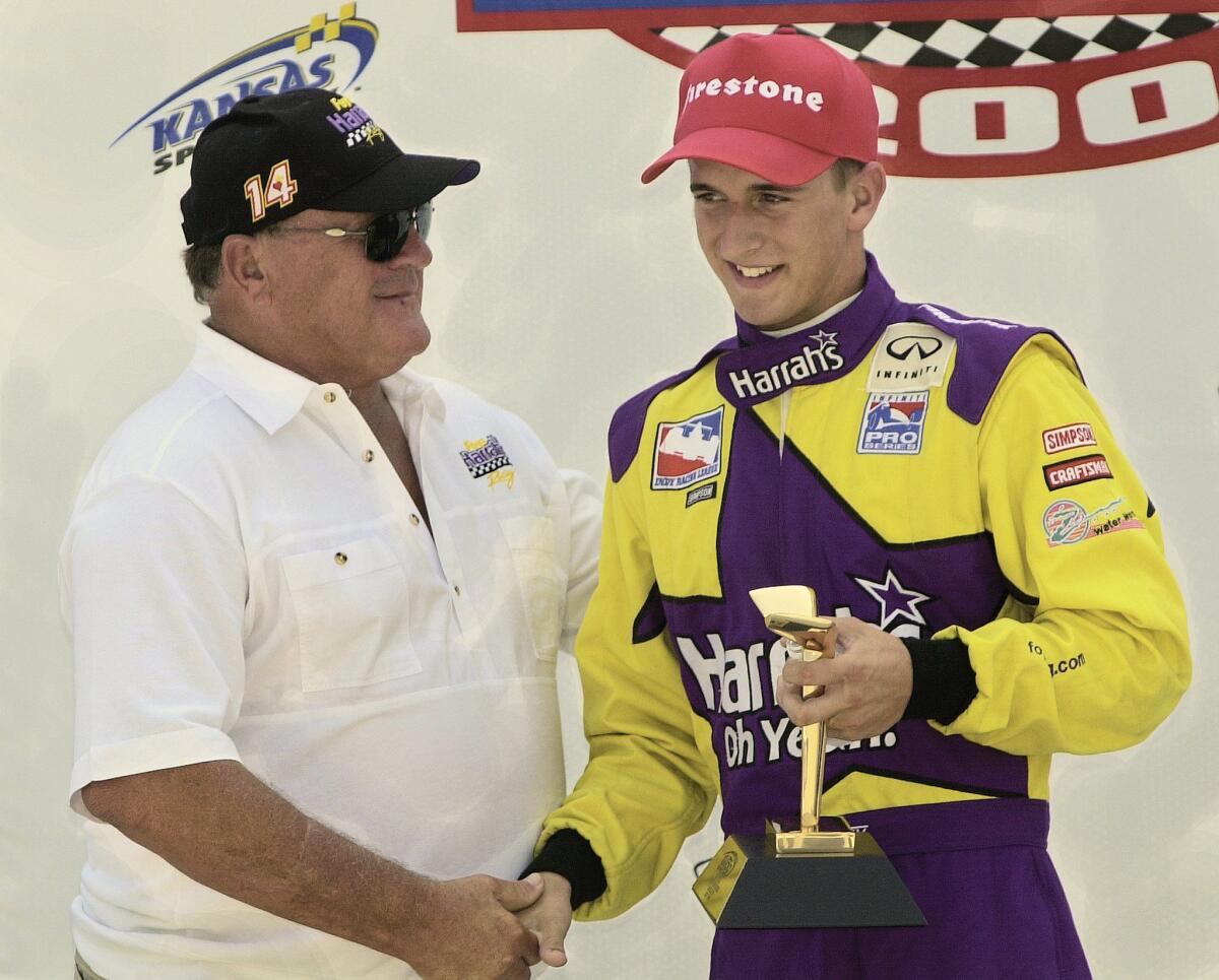 Racing legend A.J. Foyt, left, congratulates his grandson A.J. Foyt IV after his win at the inaugural Indy Racing League Inifiti Pro Series 100 at Kansas Speedway on July 7, 2002.