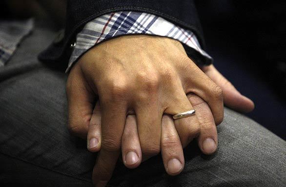 Vantha Sao, 22, who is wearing a wedding band, holds hands with husband Jay Mendes, 41, while watching the televised hearing on Prop. 8 at the West Hollywood Auditorium.