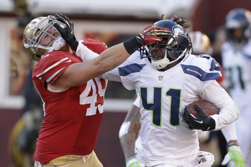 49ers fullback Bruce Miller, seen here trying to tackle Seahawks cornerback Byron Maxwell after an interception, was arrested Thursday on suspicion of spousal battery.