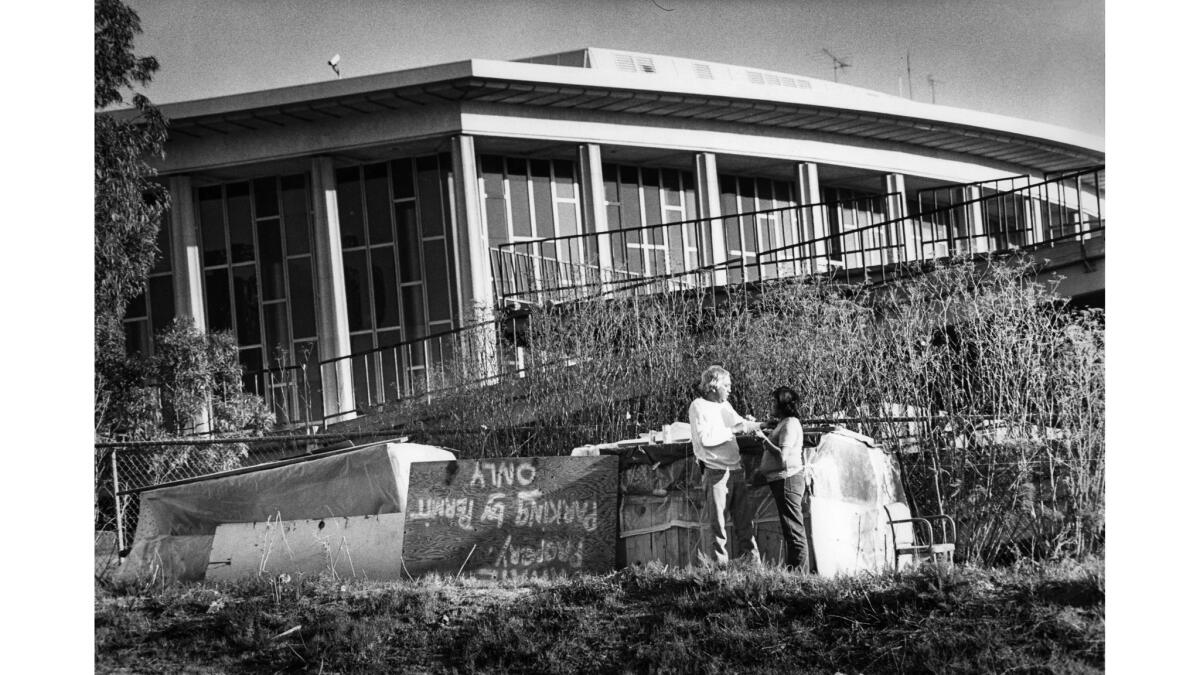 Feb. 5, 1984: Jack Yazzie and Wilma Aros talk outside their temporary home on Bunker Hill with the Music Center in background.