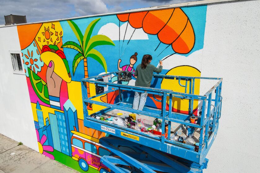 Hanna Gundrum paints a mural promoting San Diego on an L.A. building in a campaign to attract tourists to sunny San Diego.