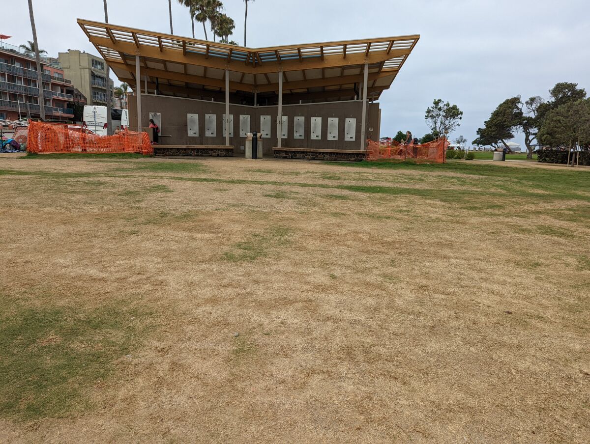 The Scripps Park restroom facility is partially fronted by dead grass.