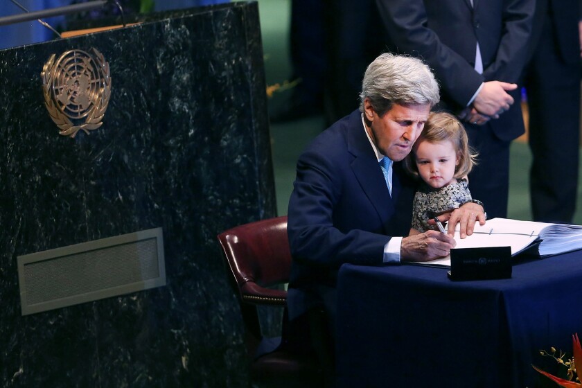 U.S. Secretary of State John F. Kerry holds his 2-year-old granddaughter, Isabel Dobbs-Higginson, for the signing of the accord at the United Nations.