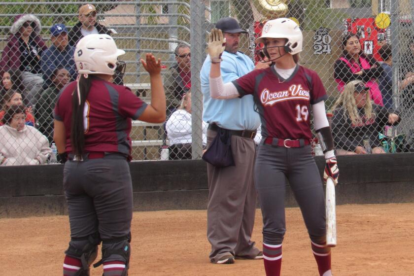 Ocean View's Sienna Erskine (19) and Kaylah Arteaga high-five after Erskine scored in the seventh inning against Katella.