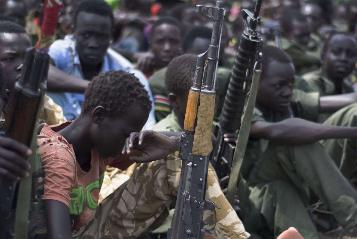 Young boys sit with rifles during a child soldier disarmament, demobilization and reintegration ceremony overseen by UNICEF on Feb. 10 in Pibor, South Sudan.