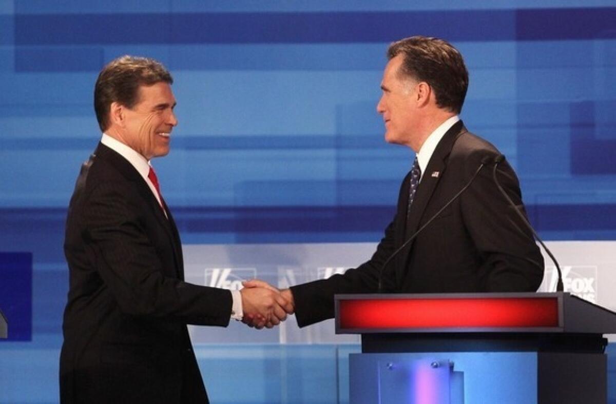 Rick Perry shakes hands with Mitt Romney after the Fox News Channel debate at the Sioux City Convention Center in Sioux City, Iowa, on Thursday. The two have logged the most debate face time, according to a study from the University of Minnesota.