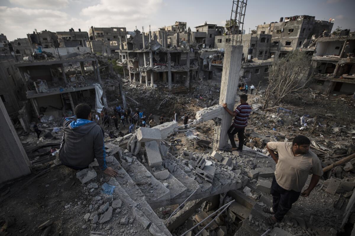 Palestinians inspect their destroyed houses in Gaza. 