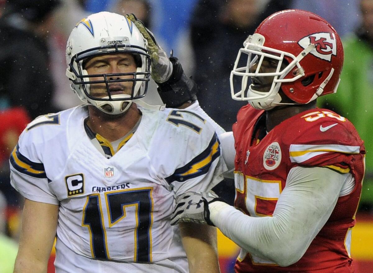 Chiefs linebacker Dee Ford (55) pats Chargers quarterback Philip Rivers (17) on the helmet after sacking him during the second half.