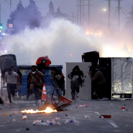Protestors run away from tear gas during a protest in the middle of a road