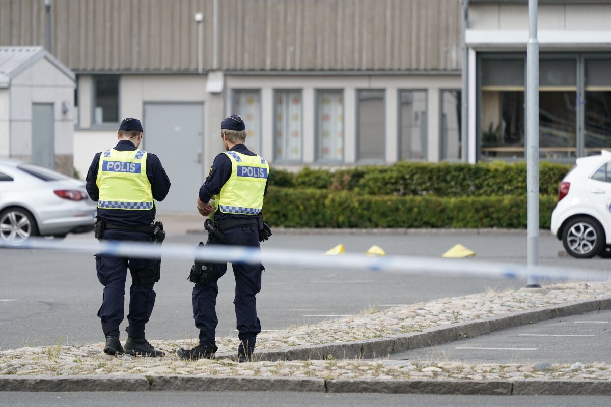 Poolice stand at the scene of a shooting incident, in the Nasby area, of Kristianstad, Sweden, Tuesday, Aug. 3, 2021. Police say that at least two people have been injured in a shooting in the southern Swedish city of Kristianstad. Swedish police received an alert on Tuesday afternoon that several loud bangs had been heard. According to preliminary information, no one was killed. (Johan Nilsson/TT News Agency via AP)