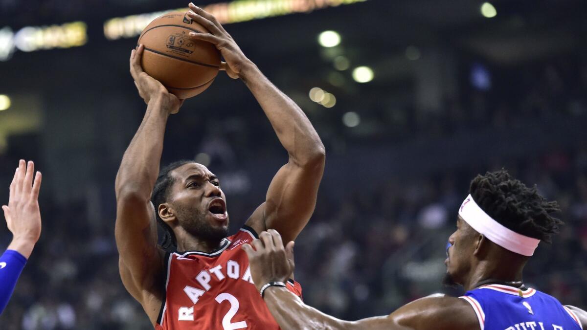 Philadelphia 76ers guard Jimmy Butler (23) fouls Toronto Raptors forward Kawhi Leonard (2) as he looks for the shot during the first half of an NBA basketball game, Wednesday, Dec. 5, 2018 in Toronto. (Frank Gunn/The Canadian Press via AP)