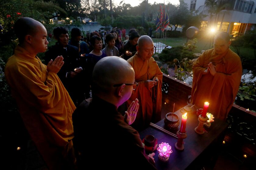 SANTA ANA, CALIF. - MAY, 2022. Buddhist monks lead prayers during a vigil for victims of the coronavirus, held on Tuesday night, May 17, 2022, at Viet Heritage House and Garden in Santa Ana.d. About 30 members of the Vietnamese - American community joined the vigil, which marked more than 1 million Americans dead from COVID-19. (Luis Sinco / Los Angeles Times)