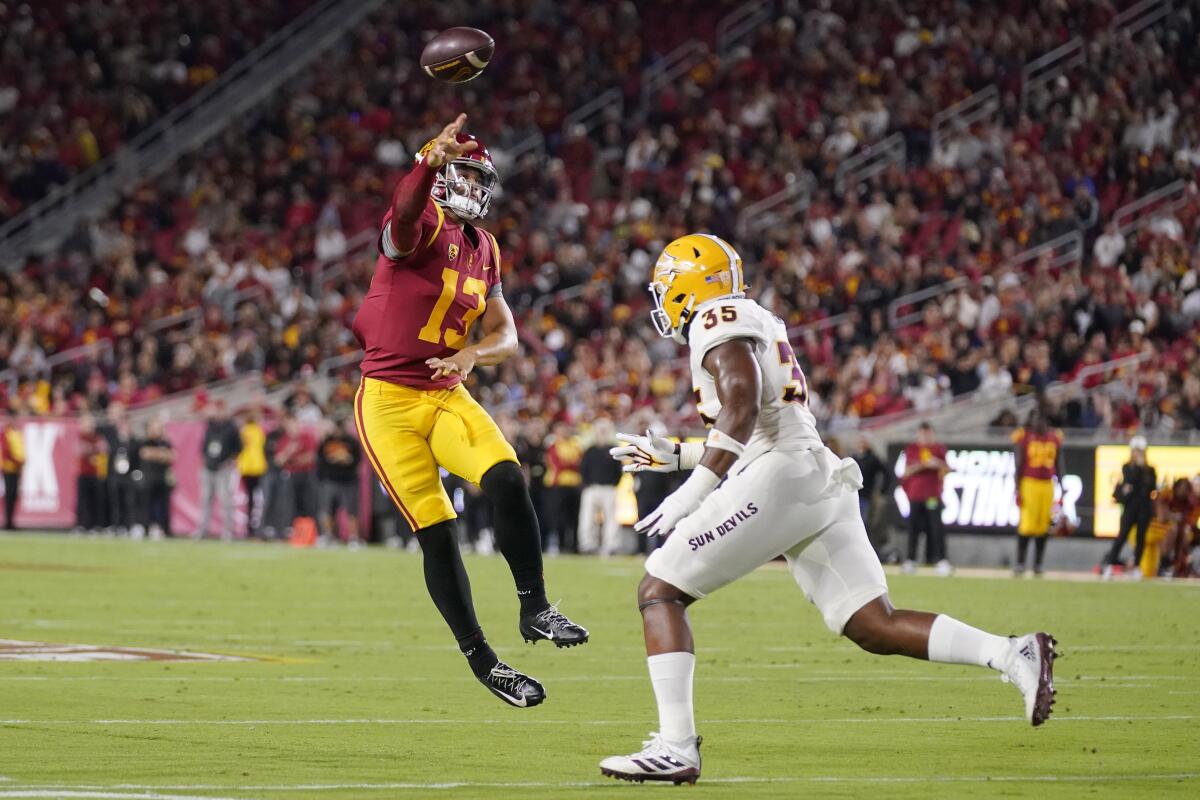 Southern California quarterback Caleb Williams, left, throws a touchdown pass as Arizona State defensive lineman B.J. Green II defends during the first half of an NCAA college football game Saturday, Oct. 1, 2022, in Los Angeles. (AP Photo/Mark J. Terrill)