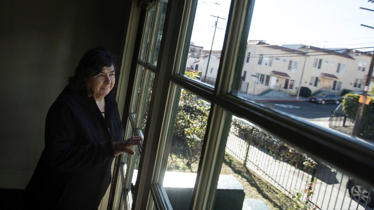 Burlington Avenue resident Maria Benitez on the front porch of her apartment building.