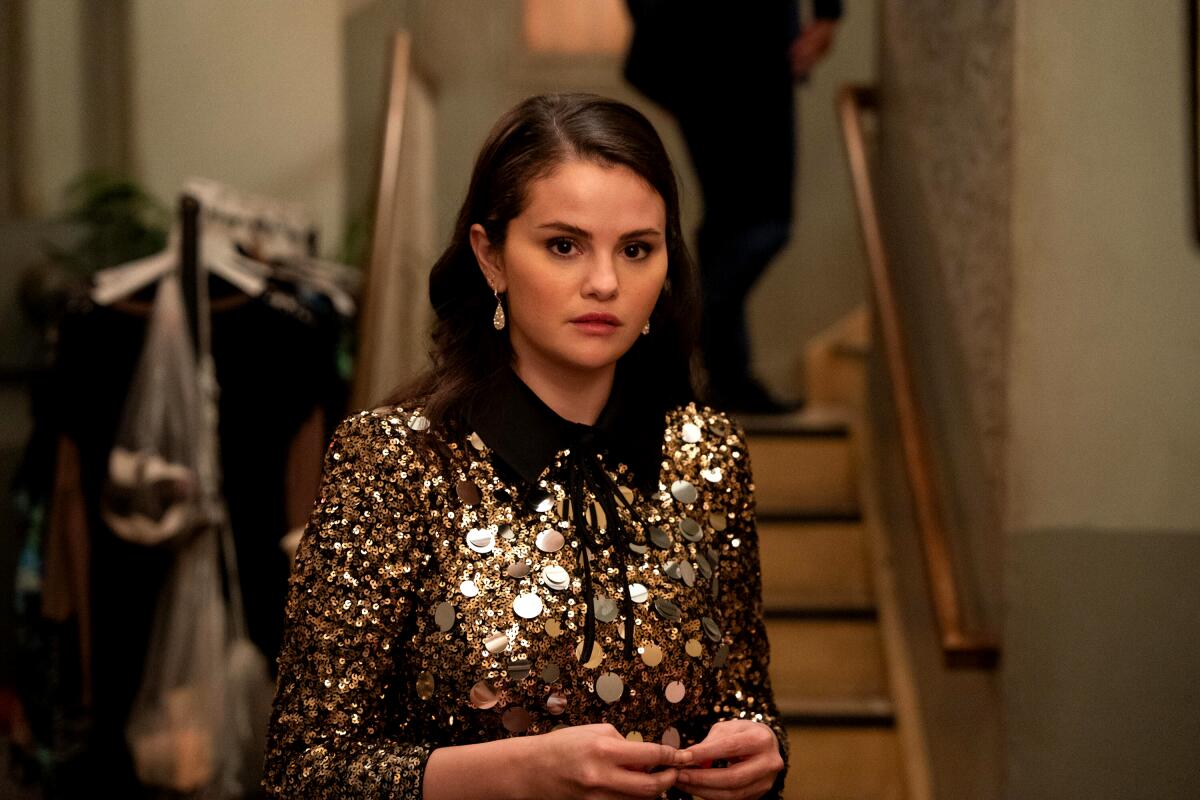 A young woman wears a glittery sequined dress while looking serious in "Only Murders in the Building."
