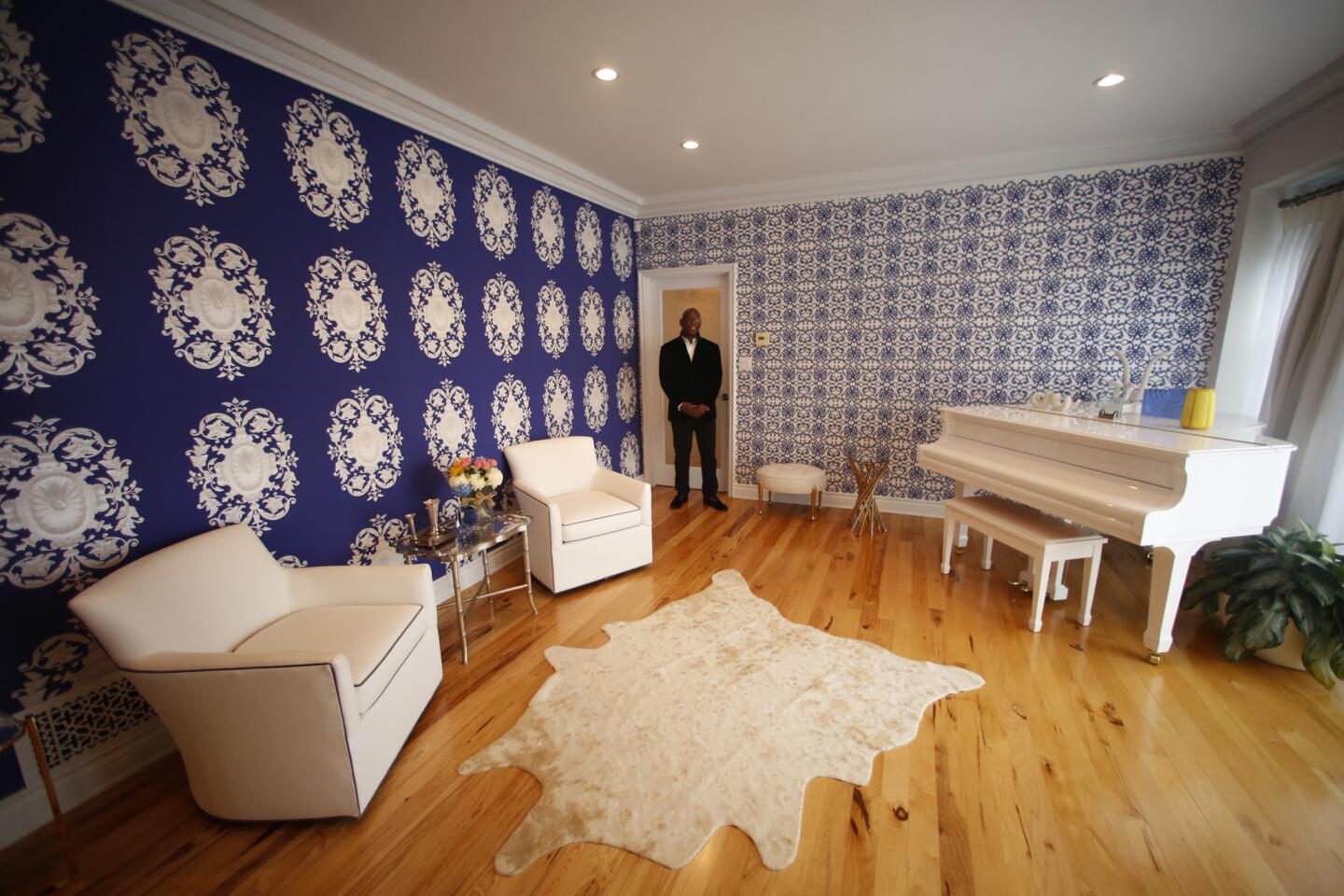Thurmond stands in his living room, which includes two contrasting yet compatible wallpaper designs