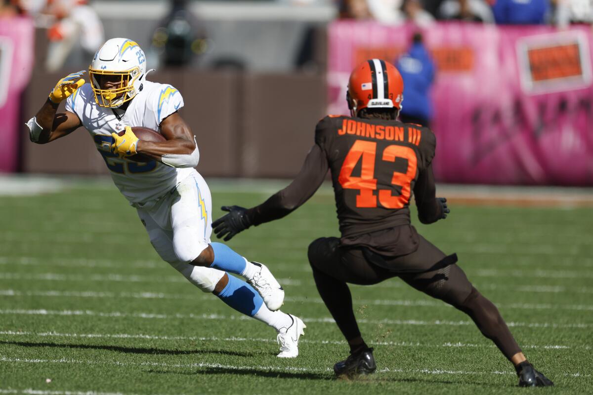 Chargers running back Joshua Kelley (25) runs after making a catch in front of Cleveland Browns safety John Johnson III.