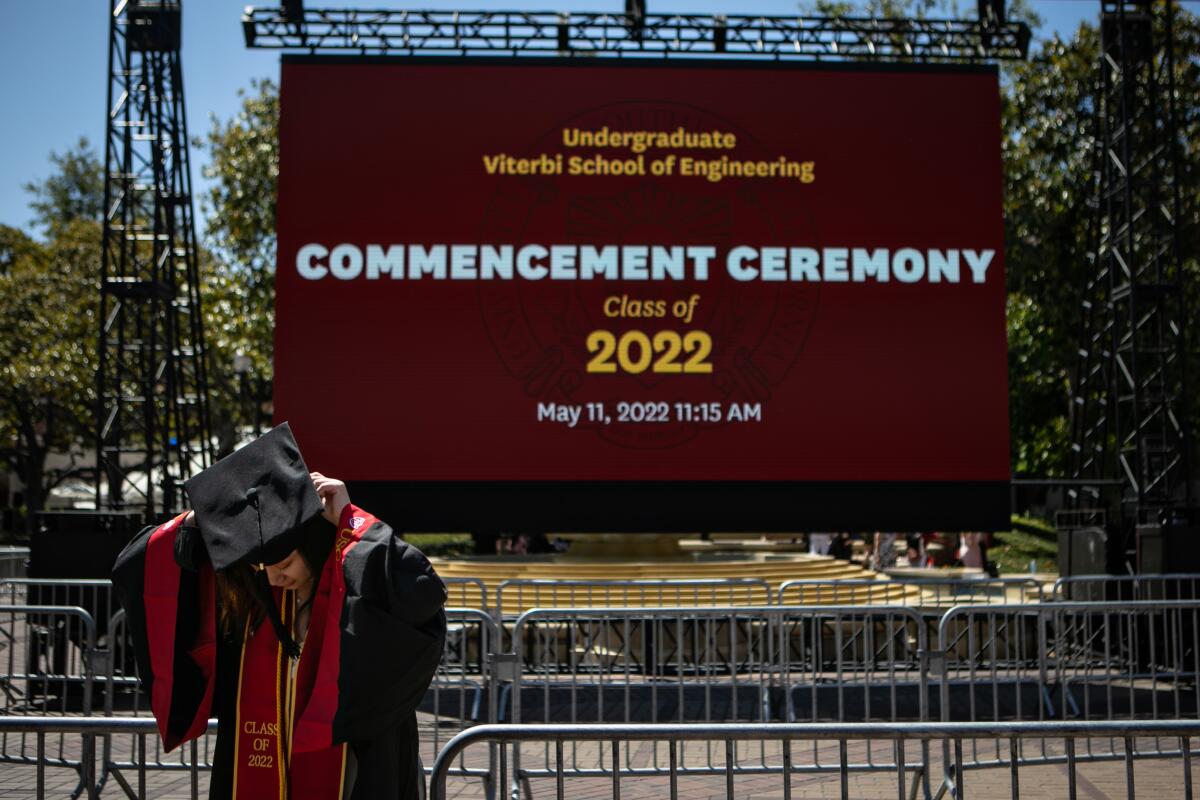 A graduate puts on her cap before posing for a photo at USC's commencement ceremony in Los Angeles on May 13, 2022.