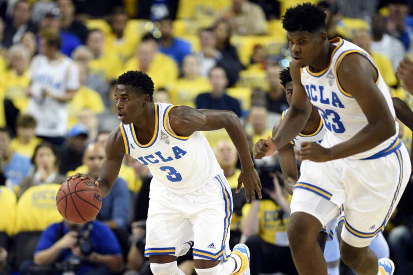 UCLA guard Aaron Holiday, left, moves the ball down the court during the first half during a game against Kentucky on Dec. 3.