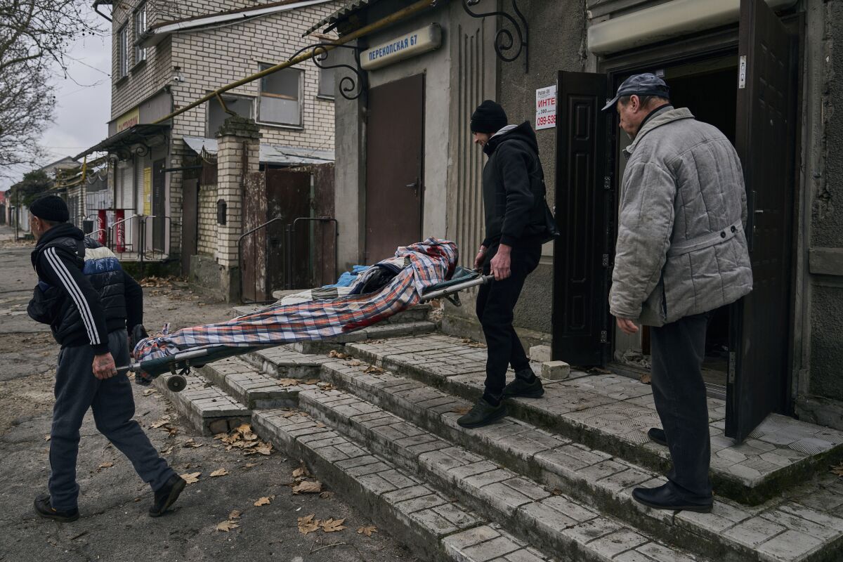 People carrying away the body of a man in Kherson, Ukraine