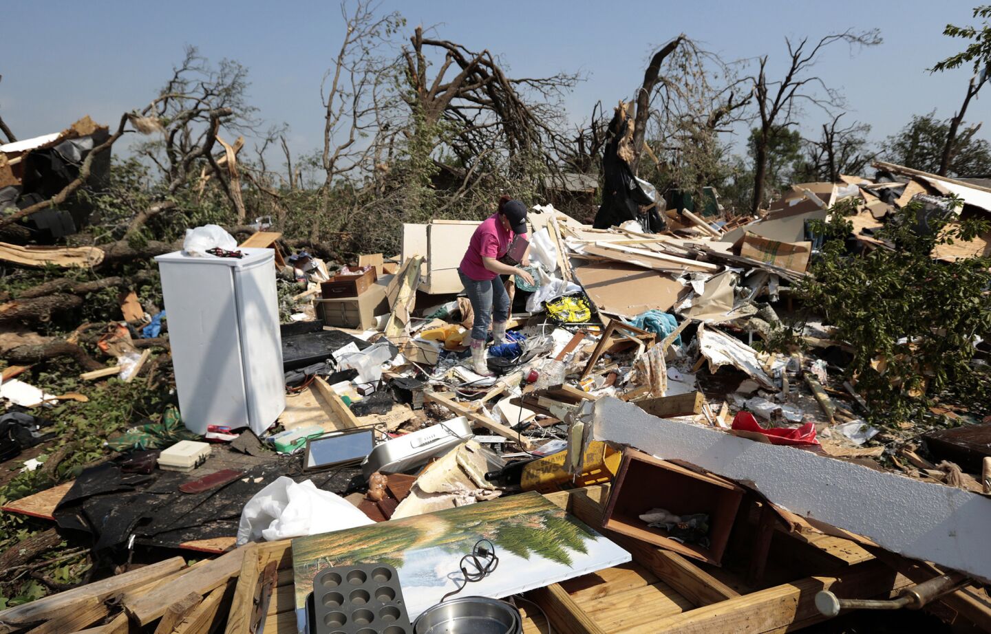 Kasey Clark sorts through the debris of her grandmother-in-law Thelma Cox's mobile home after it was destroyed by a tornado near Shawnee, Okla. A series of tornados moved across central Oklahoma on Sunday, killing two people and injuring at least 21.
