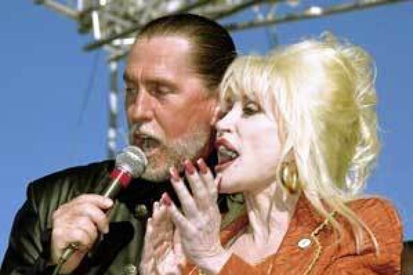 SIBLING REVELRY: Randy and Dolly Parton share a microphone at the Carolina Crossroads groundbreaking.