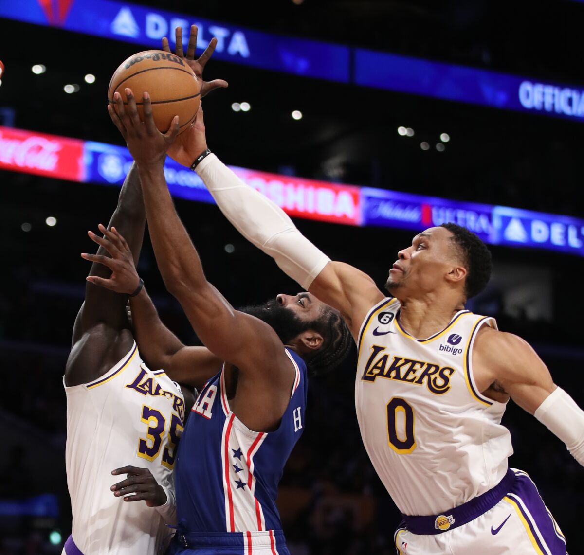 Lakers point guard Russell Westbrook tries to block a shot by 76ers guard James Harden.