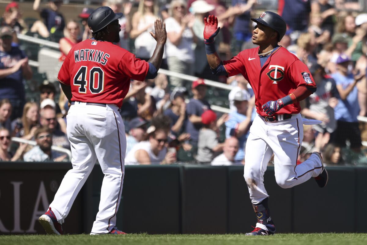 Minnesota Twins Jorge Polanco, left, high-fives third base coach Tommy Watkins (40) after hitting a home run during the sixth inning of a baseball game against the Oakland Athletics, Saturday, May 7, 2022, in Minneapolis. Minnesota won 1-0. (AP Photo/Stacy Bengs)