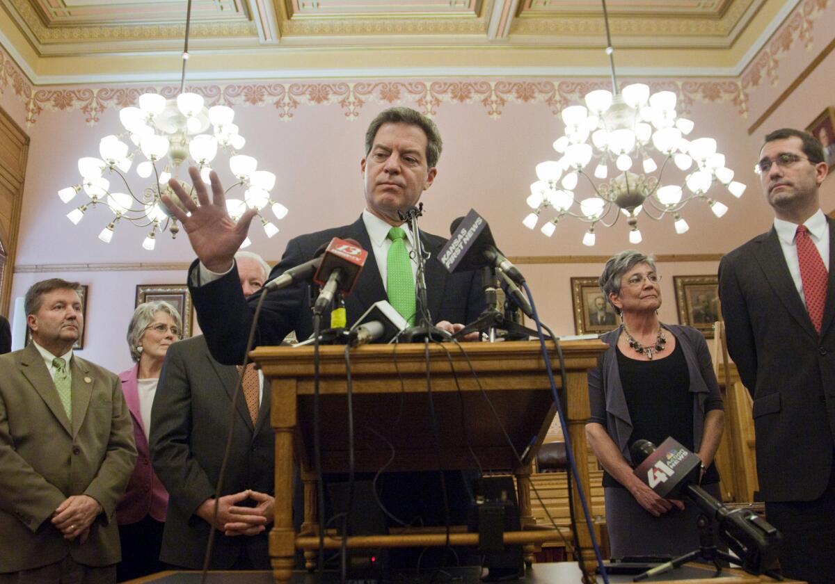 Kansas Gov. Sam Brownback promised that his steep tax cuts would supercharge the state's economy. But job growth in Kansas trails the nation. Above, Brownback at a news conference in March.