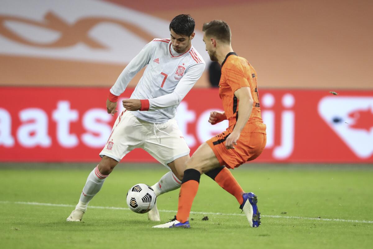 Spain's Alvaro Morata, left, and Netherlands' Joel Veltman vie for the ball during the international friendly soccer match between The Netherlands and Spain at the Johan Cruyff ArenA in Amsterdam, Netherlands, Wednesday, Nov. 11, 2020. (Dean Mouhtaropoulos/Pool via AP)