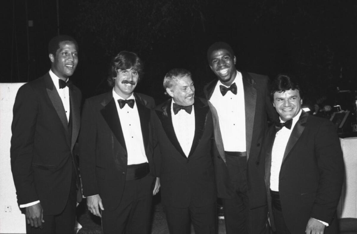 Jerry Buss, center, is joined at a 1980 event by a mix of Lakers and Kings, including Jamaal Wilkes, from left, Charlie Simmer, Magic Johnson and Marcel Dionne.