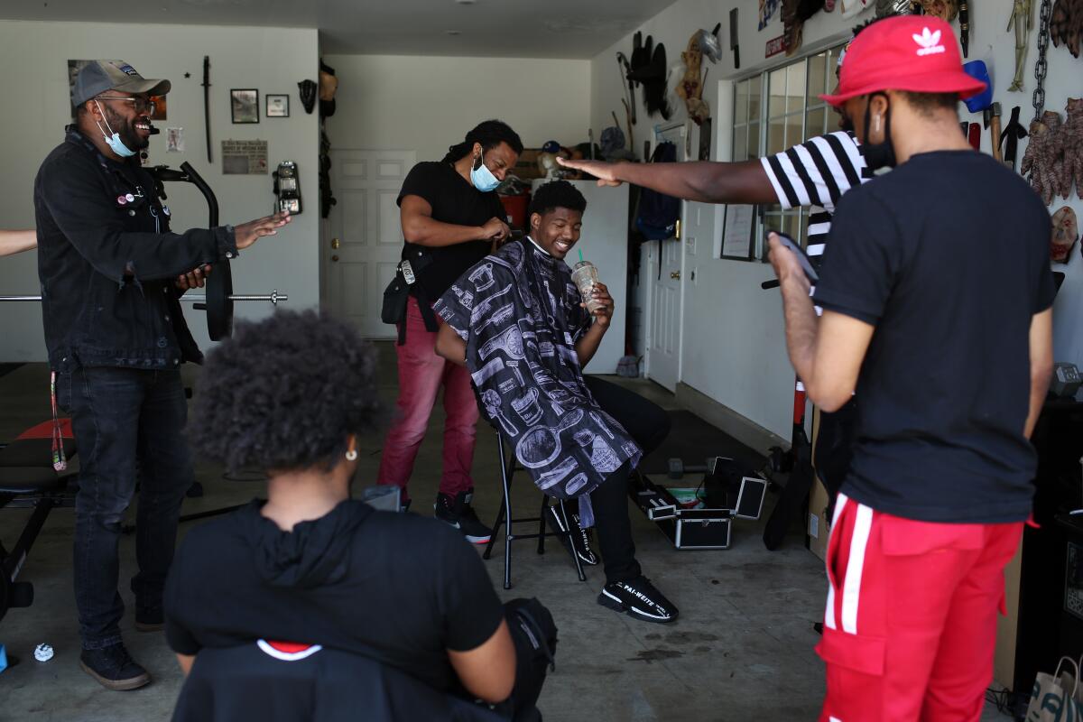 Dominique Barrett, center, known as "King Vader" on TikTok with 2.4 million followers prepares to film a video for TikTok in Glendora on Thursday, April 30, 2020.