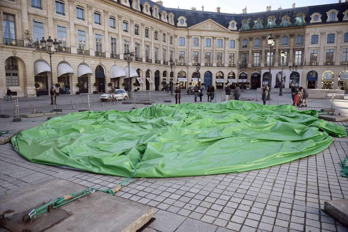 The controversial, inflatable sculpture "Tree" by L.A. artist Paul McCarthy sits deflated in Paris on Saturday, after vandals tampered with the cables securing it and the pump keeping it inflated.