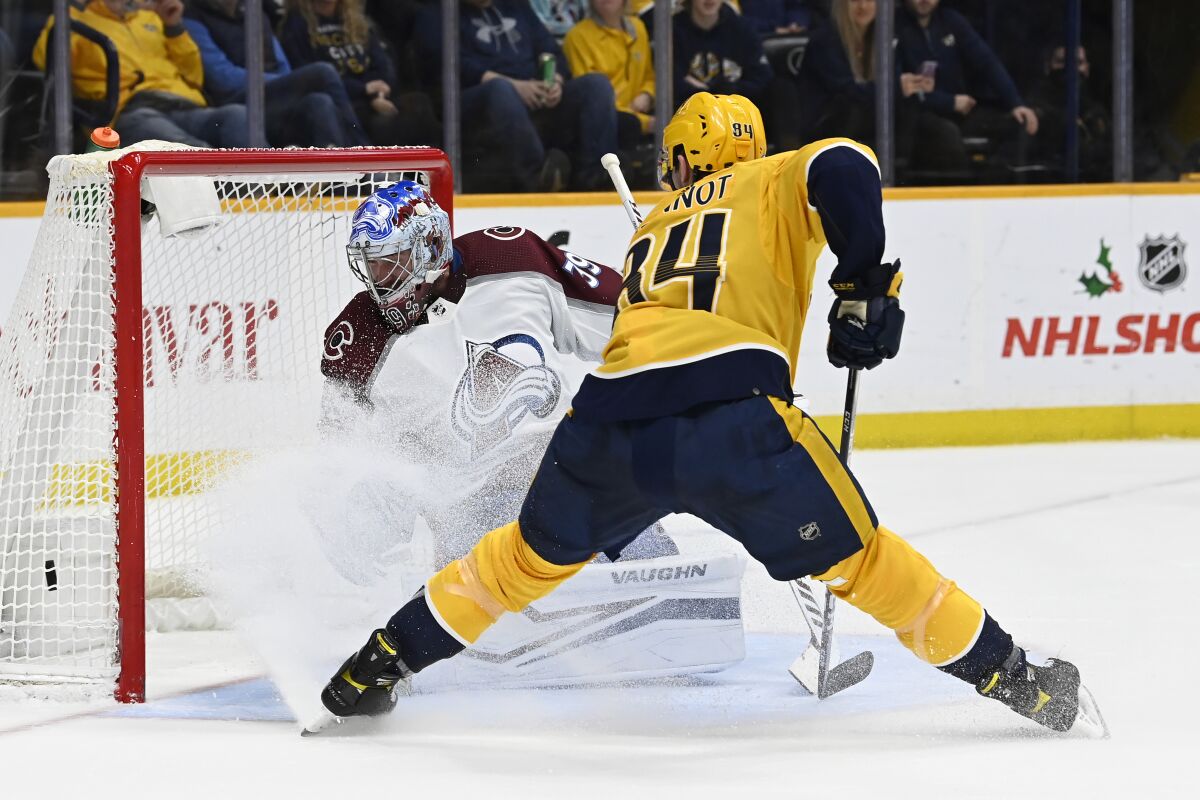 Nashville Predators left wing Tanner Jeannot (84) watches a shot by left wing Filip Forsberg get past Colorado Avalanche goaltender Pavel Francouz (39) for a goal during the second period of an NHL hockey game Thursday, Dec. 16, 2021, in Nashville, Tenn. (AP Photo/Mark Zaleski)