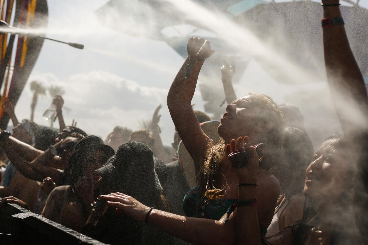 Music fans try to cool off inside the Do Lab as the temperature approached 90 on the second day of the second weekend of the Coachella Valley Music and Arts Festival in Indio.