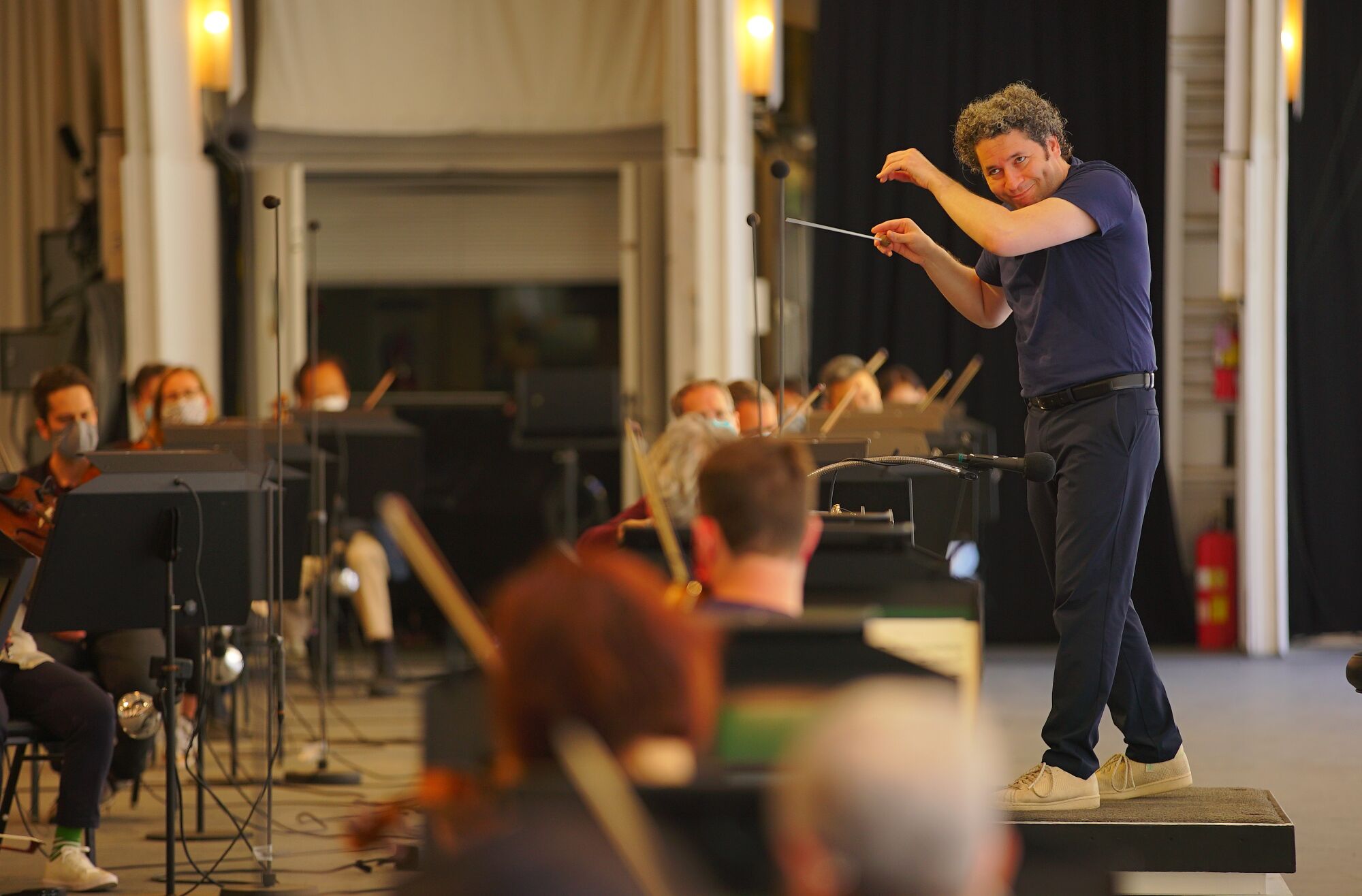 Dudamel, in tennis shoes, conducts rehearsal