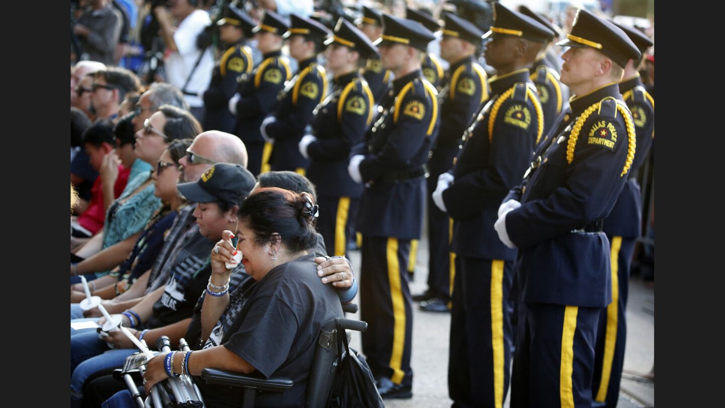 A woman wipes her tears in a section of seats reserved for family members of the slain police officers.
