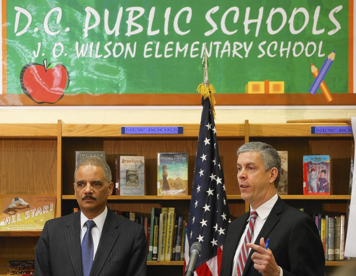 Atty. Gen. Eric H. Holder Jr., left, and Education Secretary Arne Duncan discuss results of a new civil rights study on access to education and unfair disciplinary practices in U.S. public schools during a visit to J.O. Wilson Elementry School in Washington.