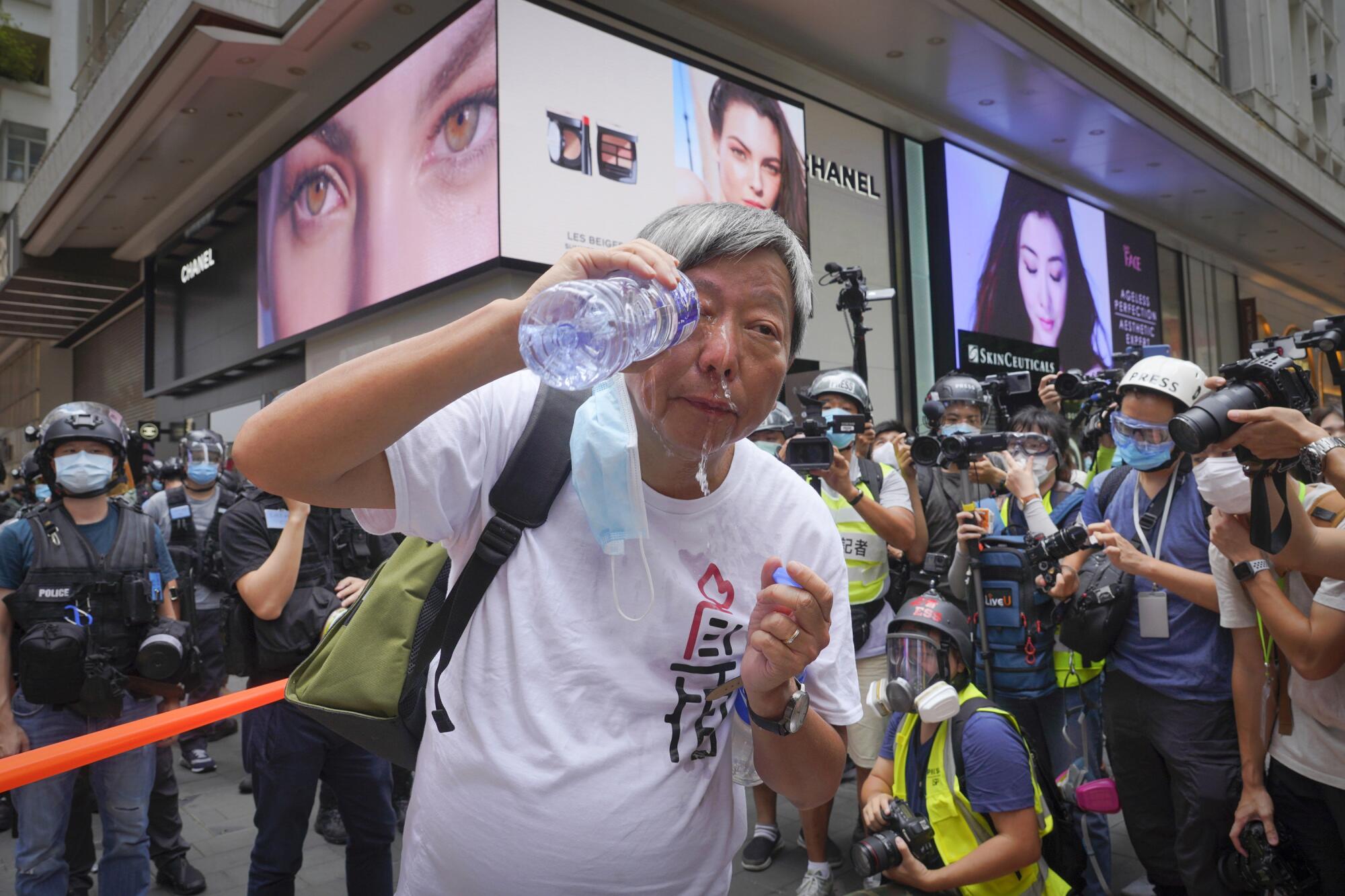 Lee Cheuk-yan washes his eyes with water after being pepper sprayed by Hong Kong police during a demonstration Wednesday.