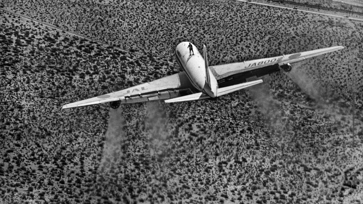 June 19, 1976: A daredevil billed as the Human Fly rides atop a DC-8 over the Mojave Desert.