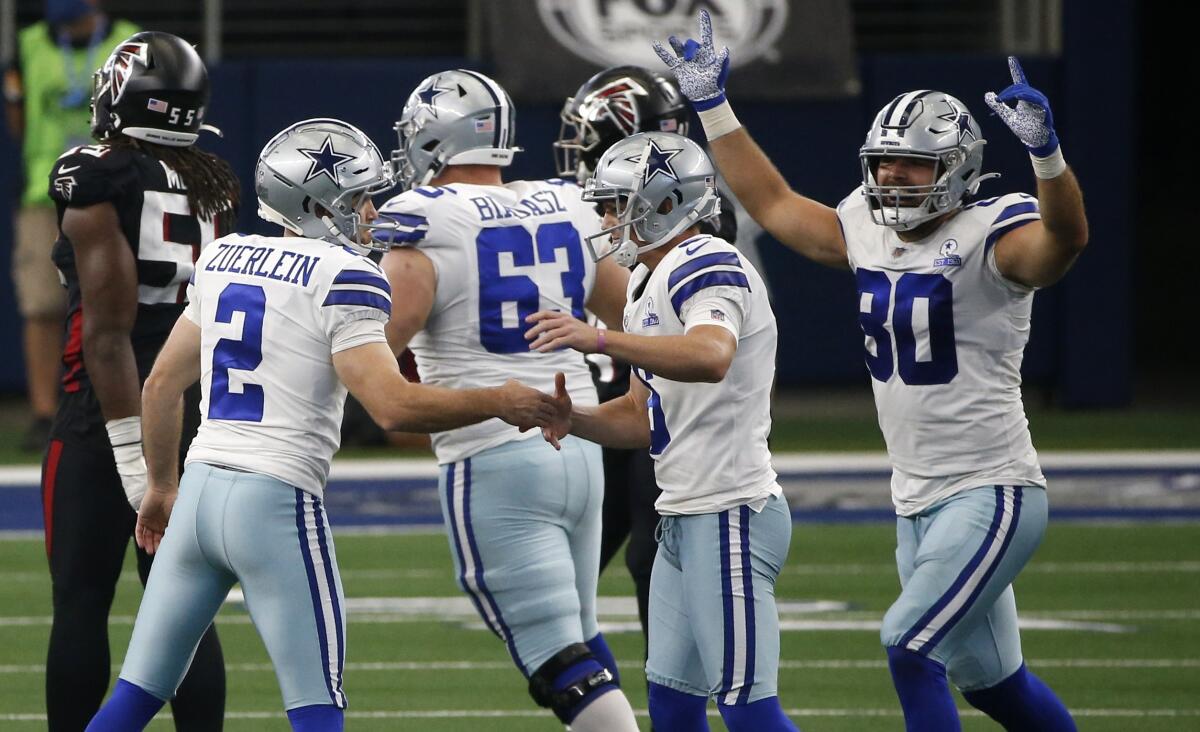 Cowboys kicker Greg Zuerlein celebrates with teammates Chris Jones and Blake Bell after kicking the winning field goal
