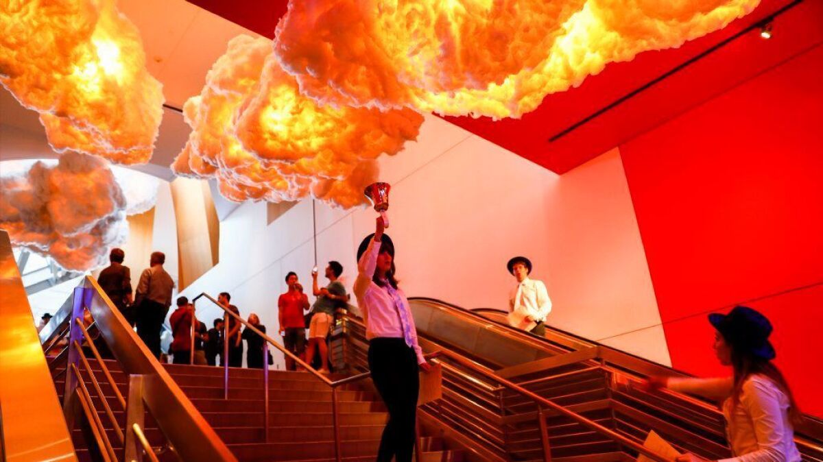Musicians sing and ring hand bells in a live, immersive performance beneath Nimbus, an art and music installation inside the Walt Disney Concert Hall.