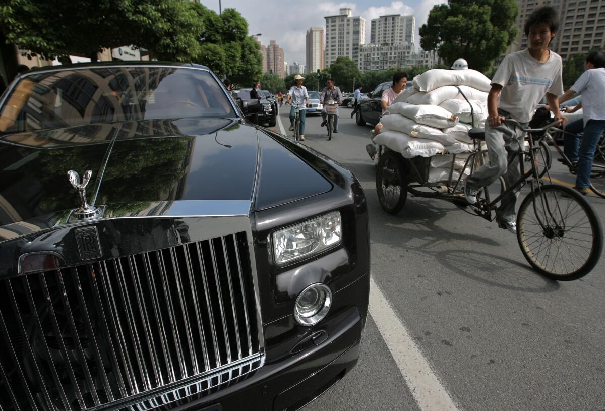 A passer-by rides a tricycle past a Rolls-Royce Phantom