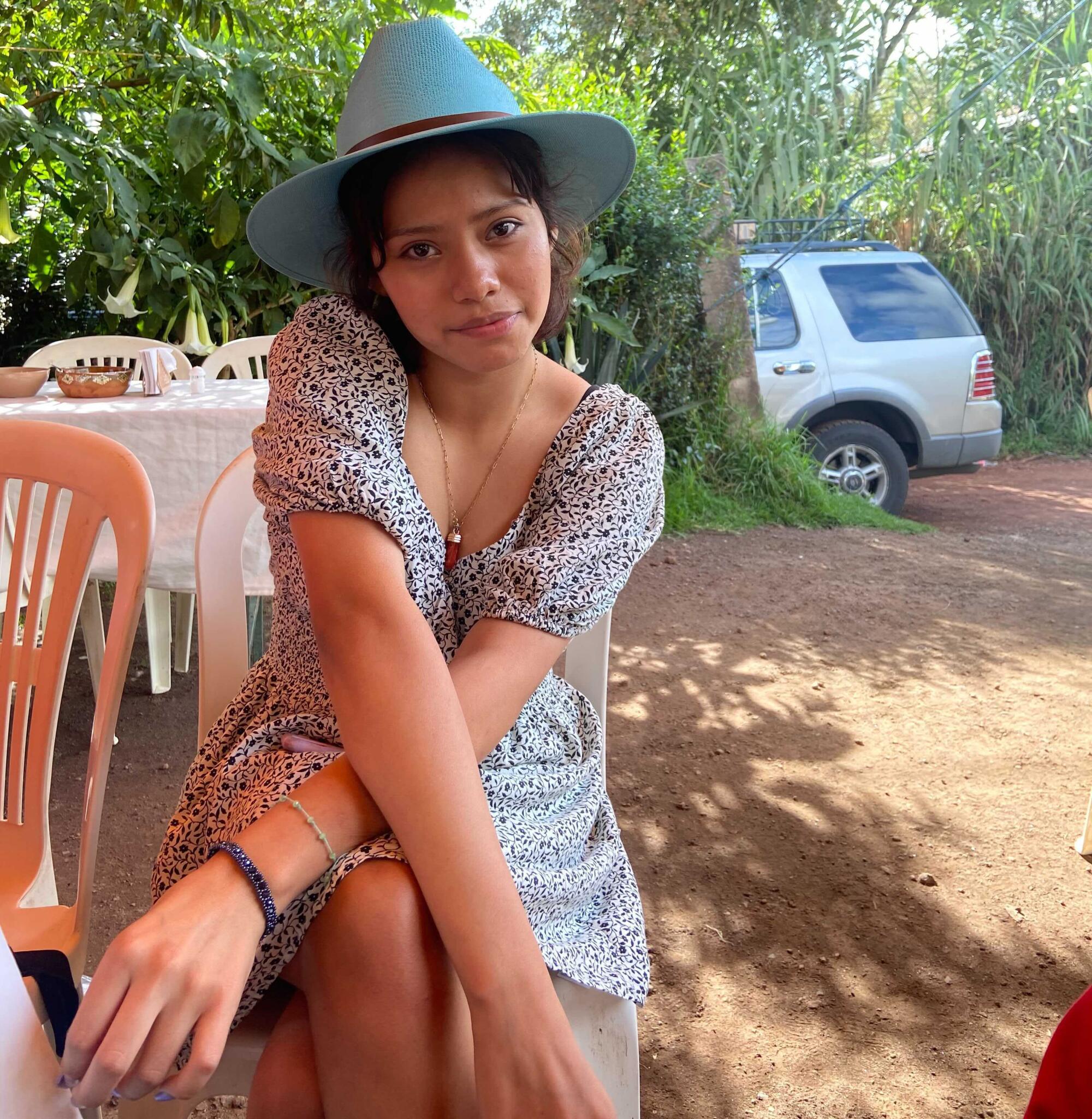 A teenager is sitting down in the shade