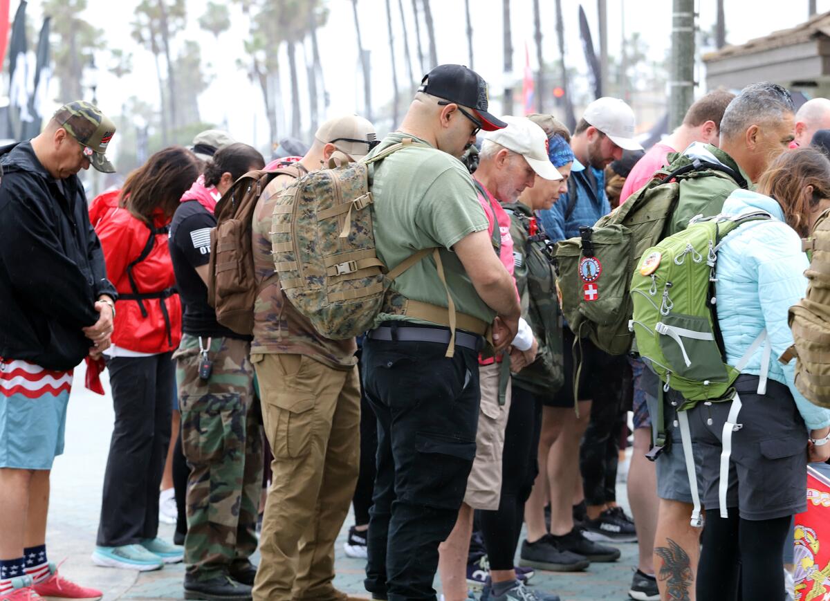Ruck march participants bow their head in prayer for 22 veterans that die by suicide a day.