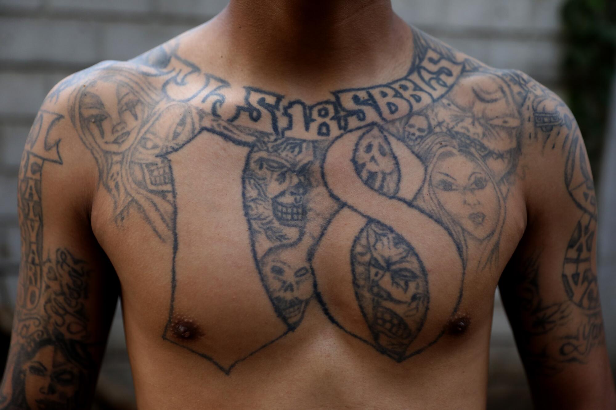 A photo of a man's chest, bearing tattoos, including one of the number 18 