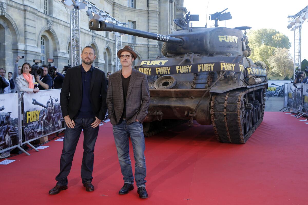 Actor Brad Pitt, right, and director David Ayer pose for photographers during the Paris premiere of "Fury."