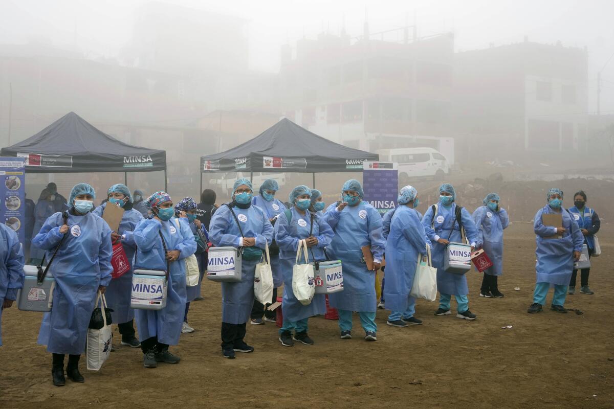 Los trabajadores de la salud sostienen hieleras con dosis de las vacunas Pfizer y Moderna para el COVID-19